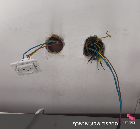שני חורים בקיר עם חוטי חשמל חשופים